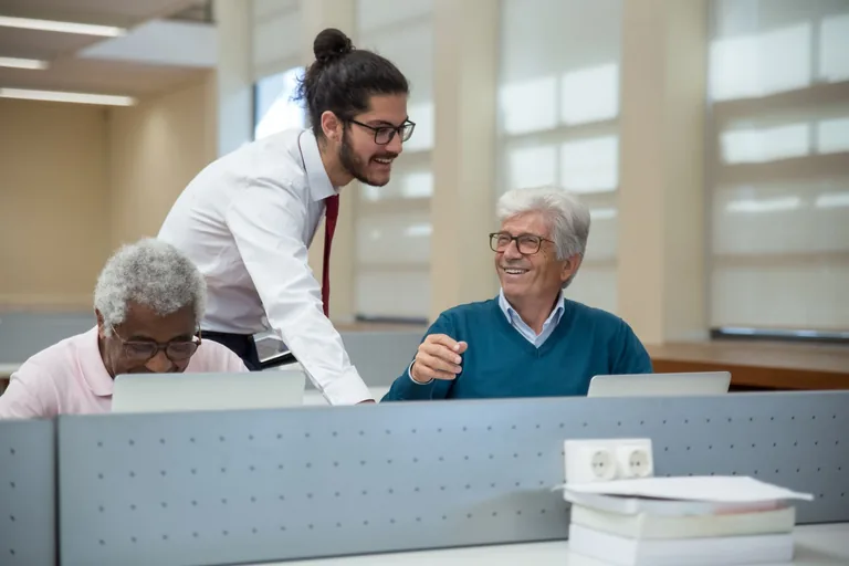 An educator helping adult learners with computers